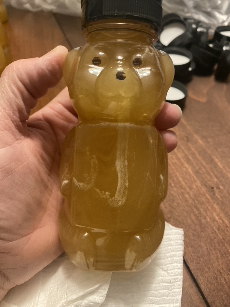 A freshly filled honey bear bottle, capped and ready for its Halo Honey label